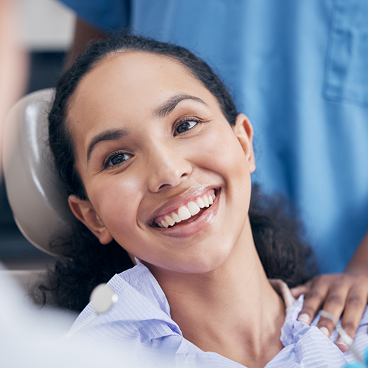 Woman in the dental chair smiling at her dentist