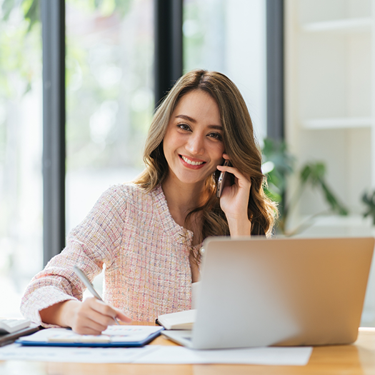 Woman talking on the phone and taking notes