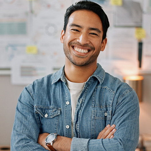Man in a denim shirt smiling after cosmetic dentistry in Maitland
