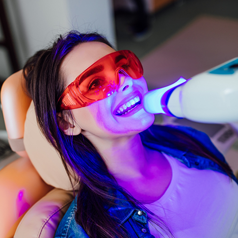 Woman in the dental chair getting professional teeth whitening