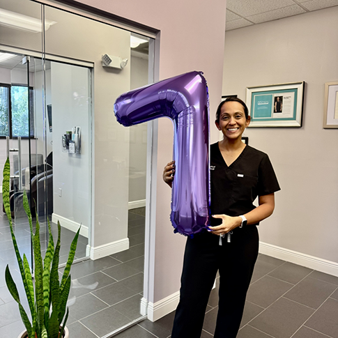 Doctor Dhaliwal holding a balloon shaped like the number 7