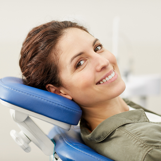 Smiling woman leaning back in the dental chair