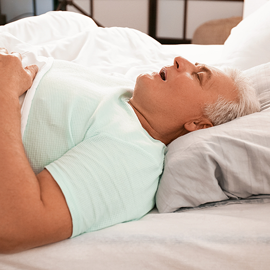 Older man sleeping on his back with his mouth open