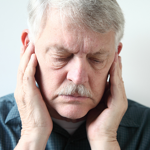 Man holding his temples in pain